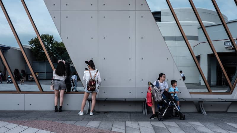 Tourists roam around a quiet Hong Kong Disneyland Resort.
