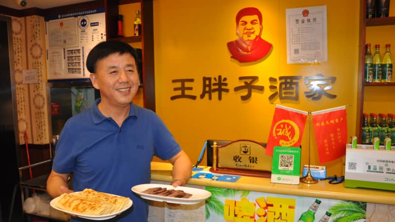 Wang Haibo, regional head of Fat Wang's Donkey Burgers, with a sample of the store's signature products in Beijing in September.