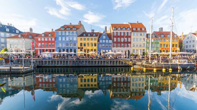 Buildings, architecture, boats and reflections along the Nyhavn in Copenhagen, Denmark. 