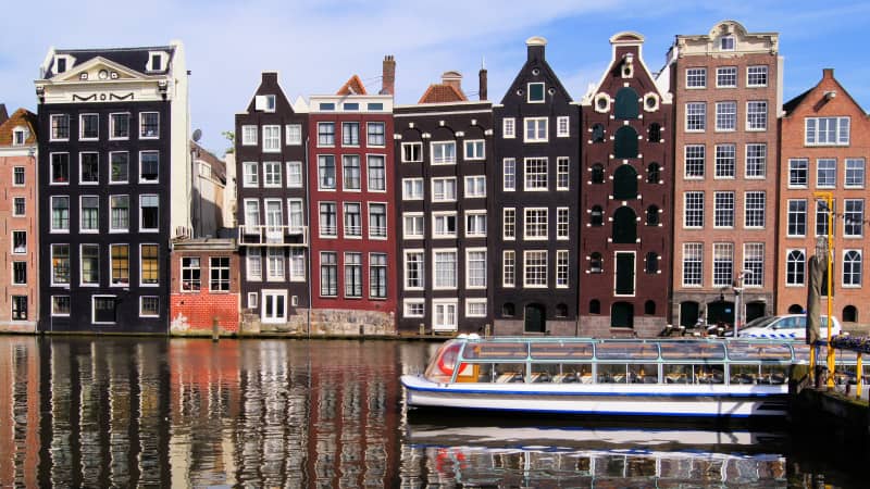 Traditional houses line canals in Amsterdam, the official capital of the Netherlands.