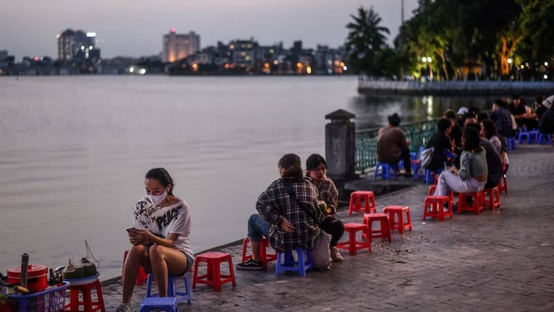 A woman sits by the lake at sunset in Hanoi on May 2. 