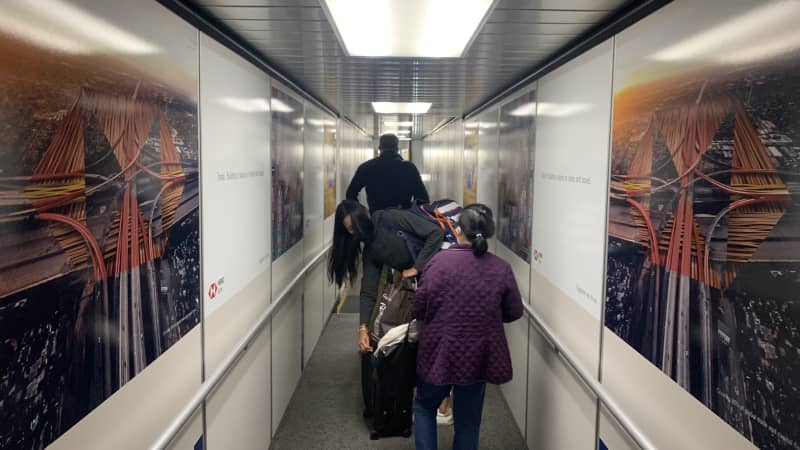 A solitary journey ends in a crowded jet way, Gate 37 at JFK Terminal 4.