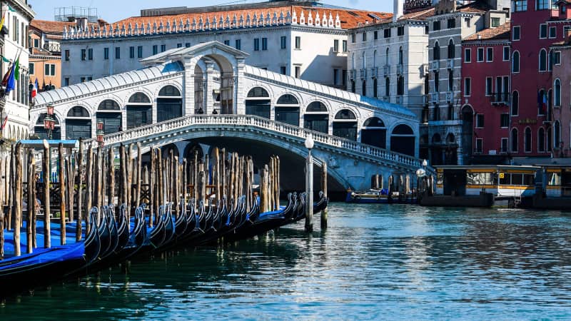 Clear waters by gondolas in Venice's Grand Canal near the Rialto Bridge on March 18, 2020 as a result of the stoppage of motorboat traffic,