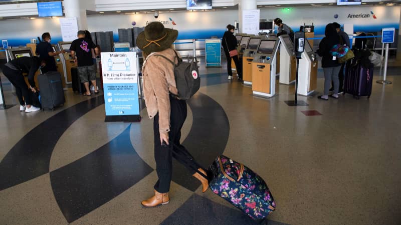 A passenger walks past a check-in area for an American Airlines, Inc. flight during the Covid-19 pandemic at Los Angeles International Airport (LAX) in Los Angeles, California, November 18, 2020
