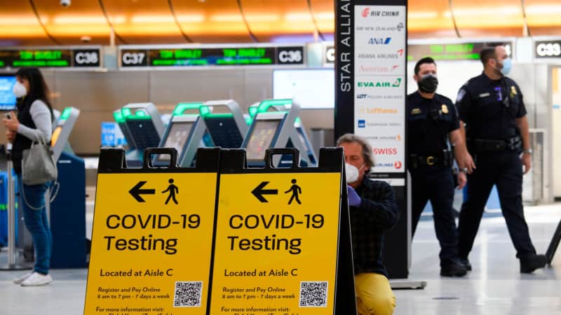 A traveler takes a photo of a Covid-19 testing sign at Los Angeles International Airport (LAX) in February 2021.