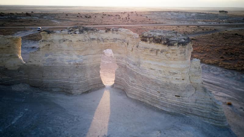 A beam of light shines through a natural arch in the chalk pyramids at Monument Rocks, Kansas.