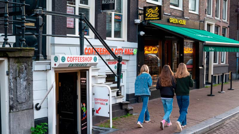 Pedestrian walk past coffee shops in the city centre of Amsterdam on January 8, 2021.