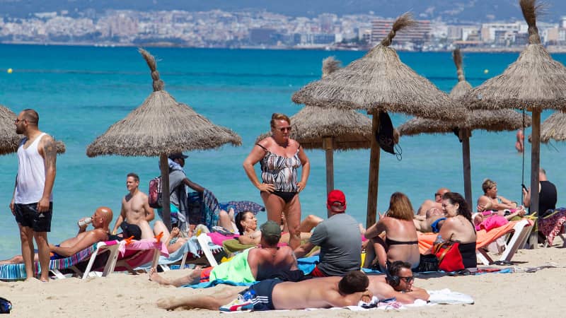 Tourists sunbathe at Palma Beach in Palma de Mallorca on June 7, 2021