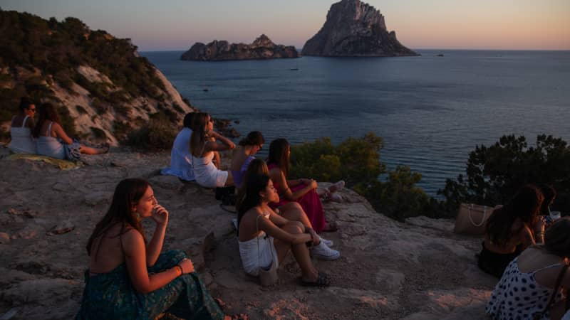 People gather at sunset at the Es Vedra viewpoint on July 16, 2021.