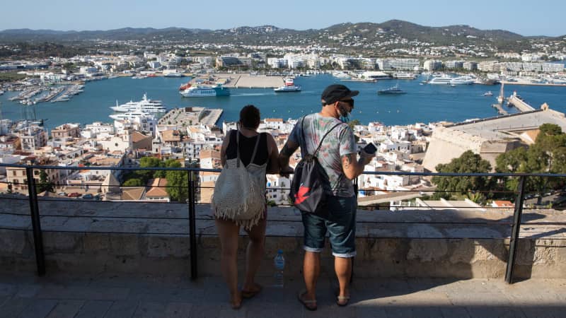 Tourists take in views of the port of Ibiza from the top of the Old Town on July 16, 2021.