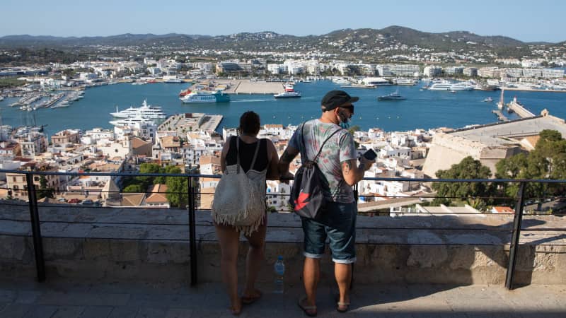 Tourists take in views of the port of Ibiza from the top of the Old Town on July 16, 2021.