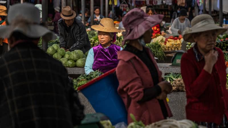 Women from the Bai ethnic group sell goods at a local market in Xizhou, Yunnan province. 