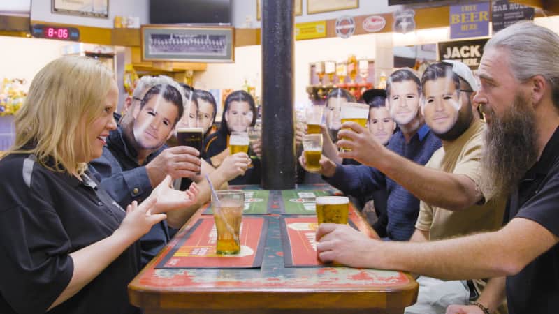 People pose in Hemsworth masks at a Cowra pub.