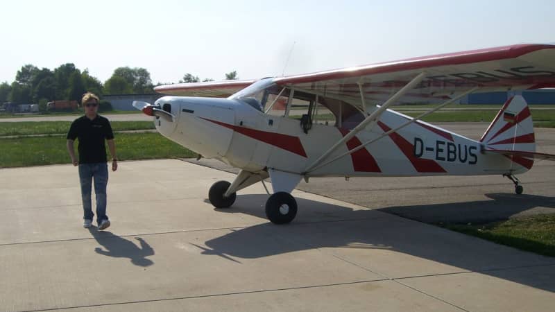 Klaus with the Piper PA-12 airplane he took Sallie flying in.