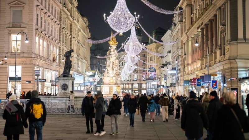 People walk among Christmas lights on November 12, 2021, near Stephanplatz in Vienna, Austria.