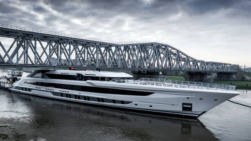 The vessel squeezes under a low bridge as it is pushed and pulled along canals and rivers.