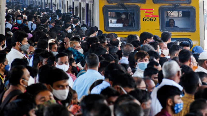 Commuters wait on the platform during rush hour as a local train arrives in Mumbai, on February 1, 2022. 