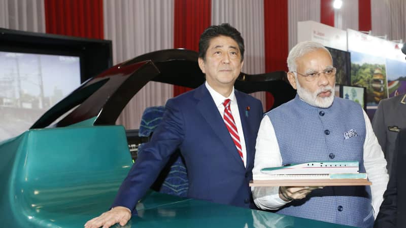 Former Japanese Prime Minister Shinzo Abe and Indian Prime Minister Narendra Modi pose in front of a high-speed train simulator in Gandhinagar, India, on September 14, 2017. 