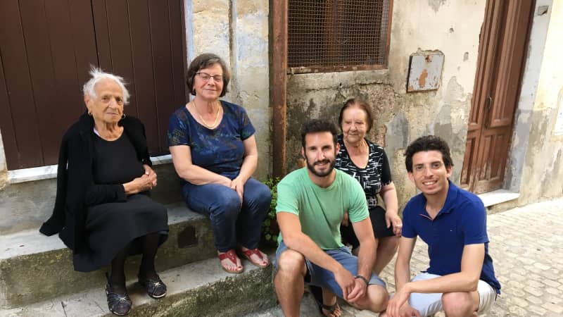 Francesco Curione, right, and a client meet with locals in the client's ancestral town.