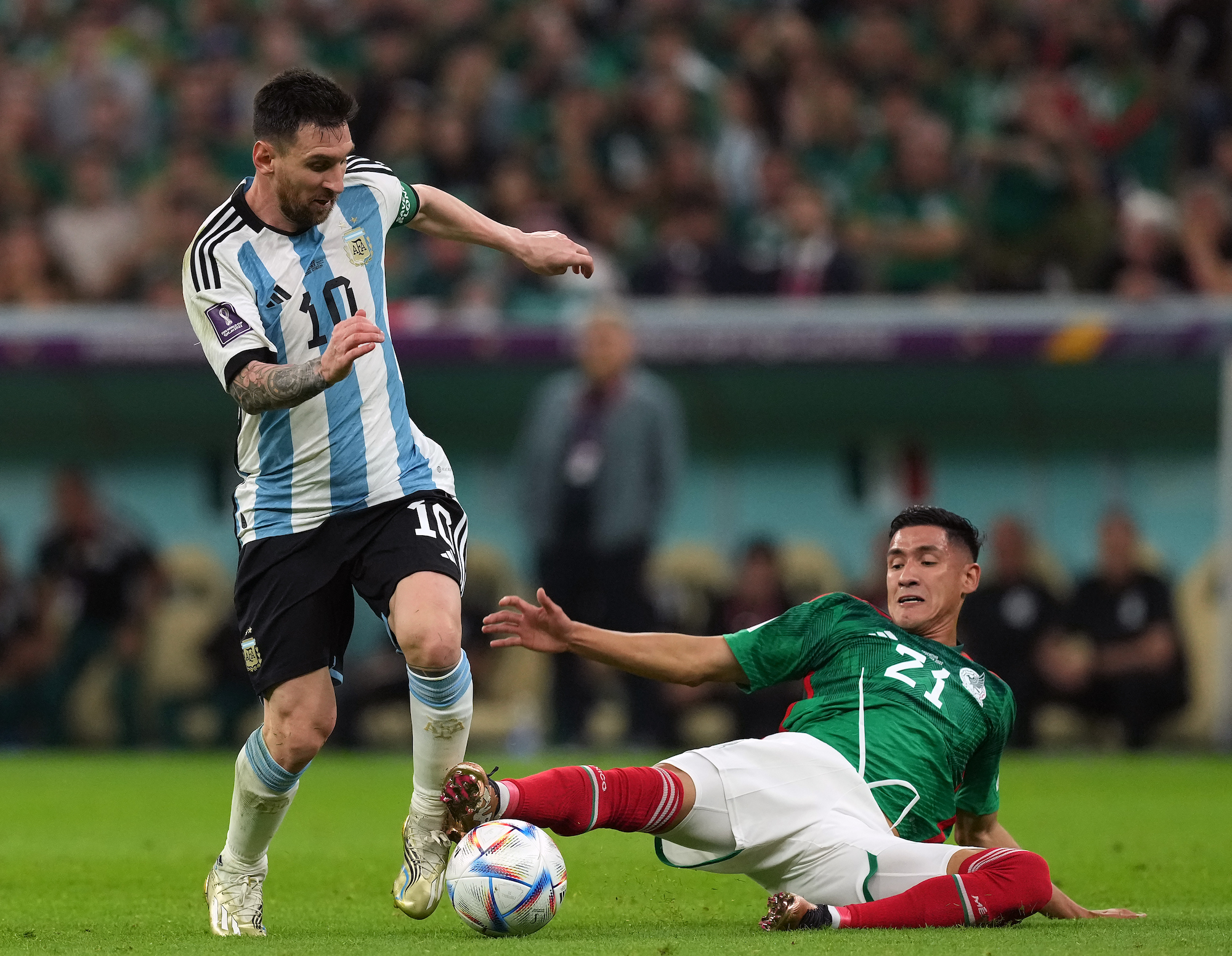 Messi battles Mexico's Uriel Antuna for the ball at Lusail Stadium on Saturday.