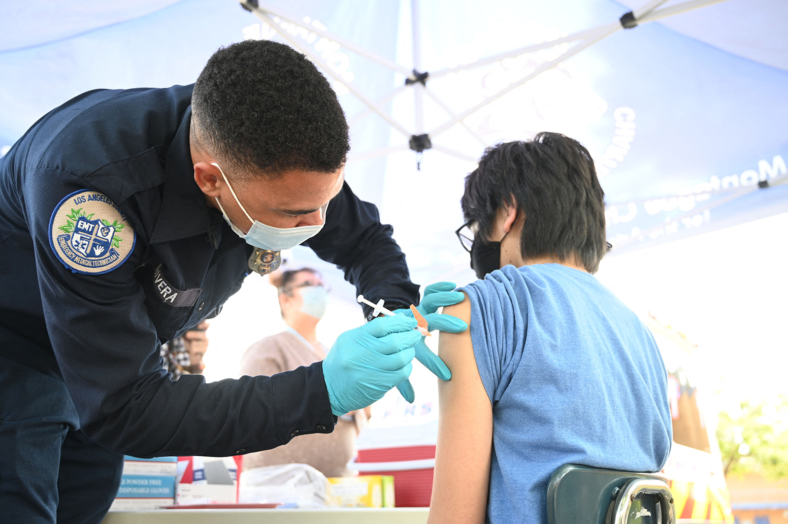 Brandon Rivera, a Los Angeles County emergency medical technician, gives a second does of Pfizer-BioNTech Covid-19 vaccine to a teenager at a pop up vaccine clinic in Los Angeles on August 23.