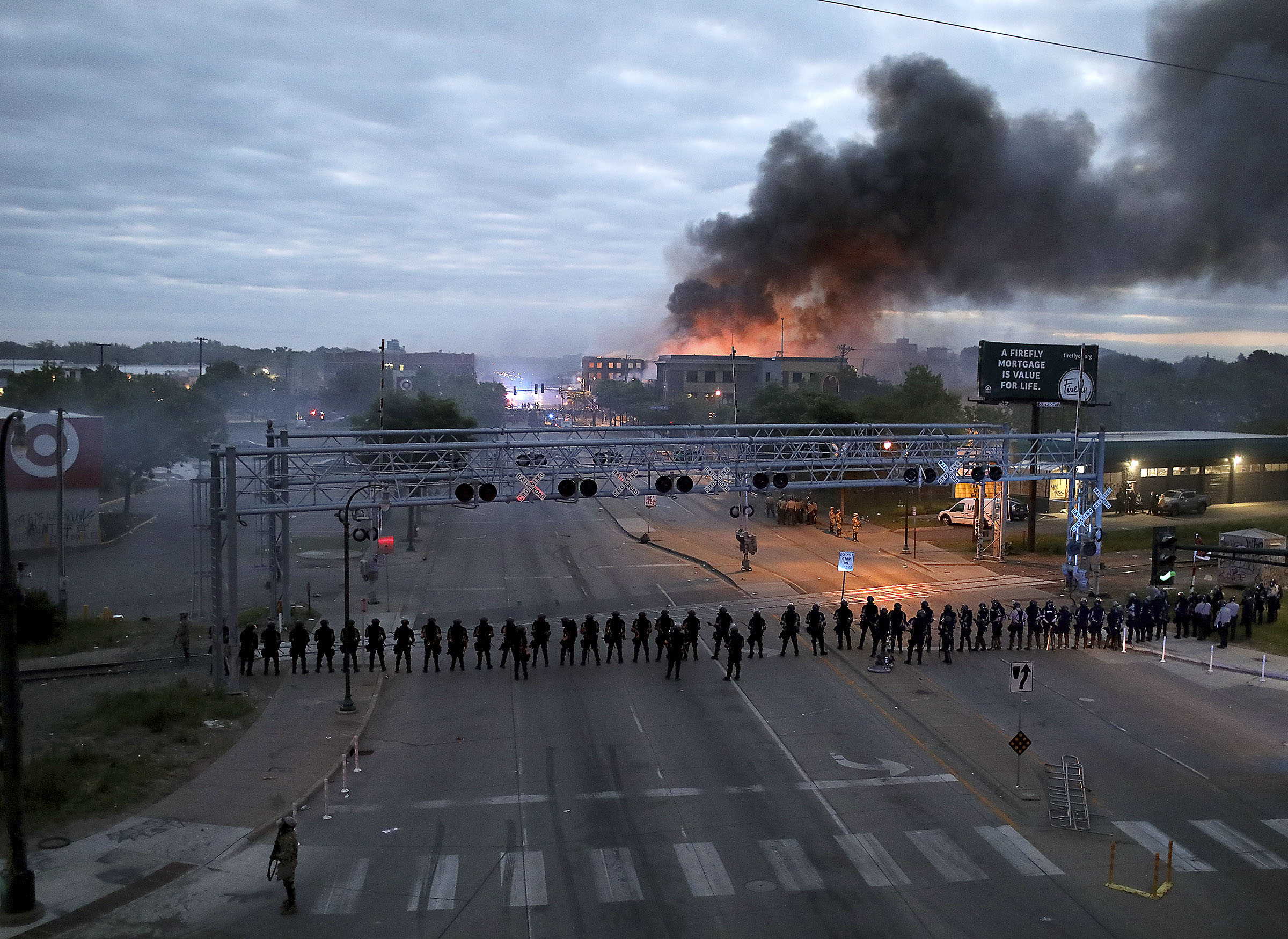 Law enforcement officers gather in Minneapolis, Minnesota, on May 29, as fires burn after a night of unrest.