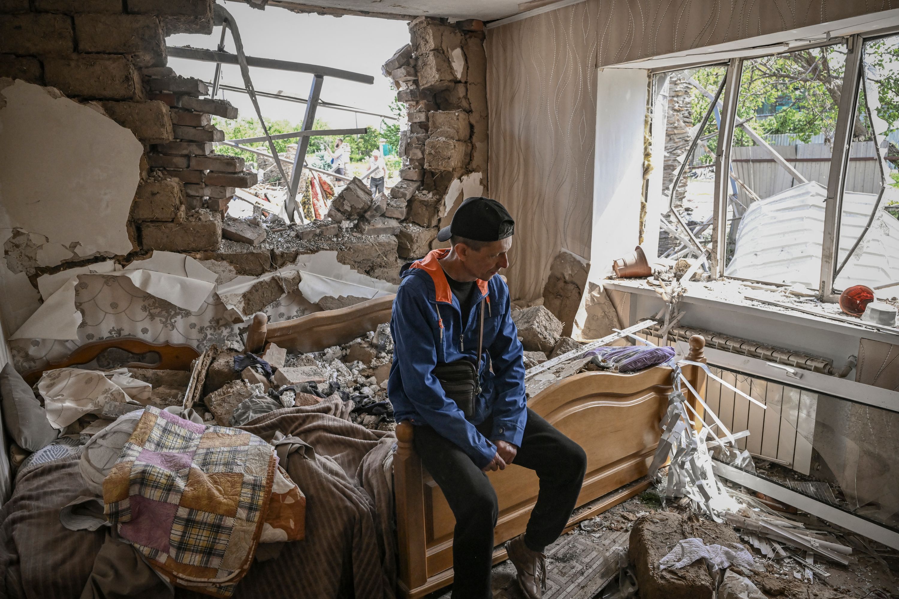 Sergiy Tarasyuk, 49, sits on his bed after a missile strike in the city of Sloviansk, the eastern Ukrainian region of Donbas, on Wednesday. Tarasyuk survived since he felt asleep in the living room the night before.