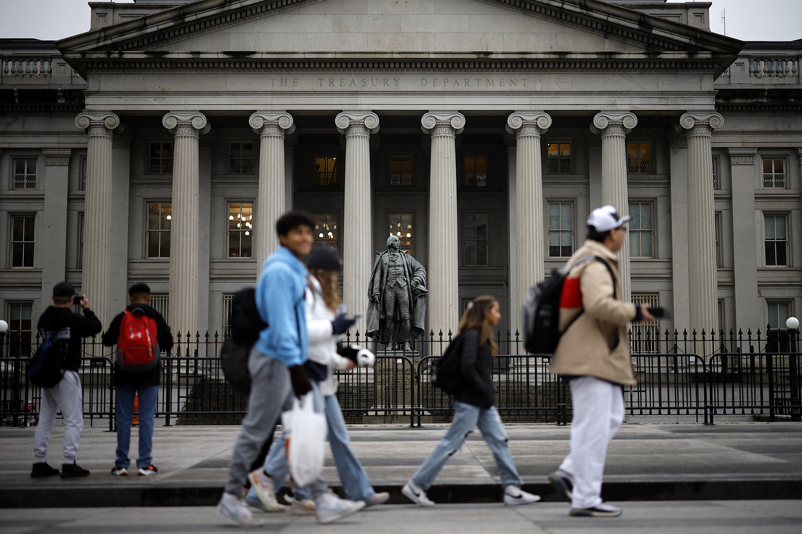 People walk past the U.S. Department of Treasury building on March 13 in Washington, DC.