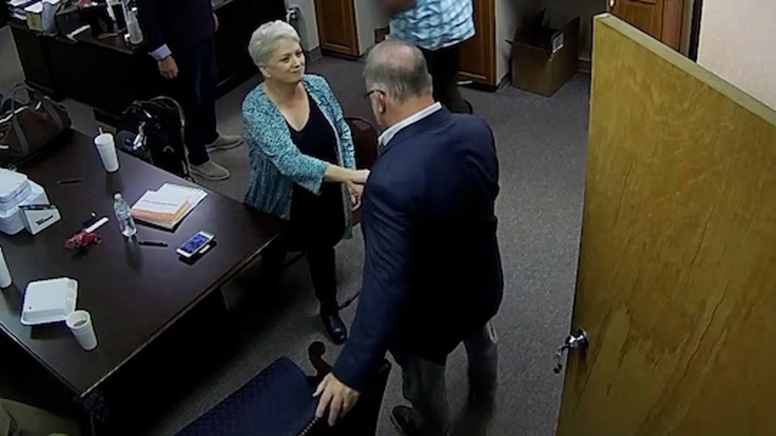 Coffee County Republican Party Chair Cathy Latham shakes hands with Georgia businessman Scott Hall on January 7, 2021 at the county election office.