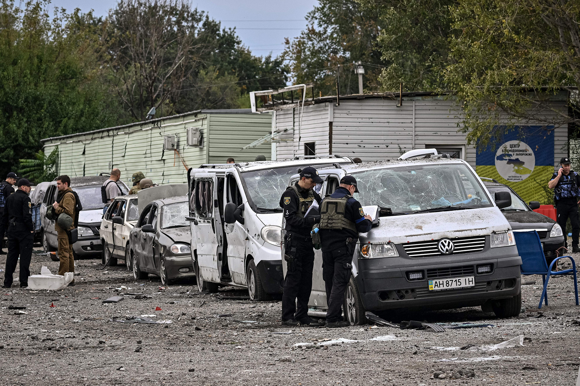 Ukrainian policemen check cars damaged by a missile strike on a road near Zaporizhzhia, Ukraine, on September 30.