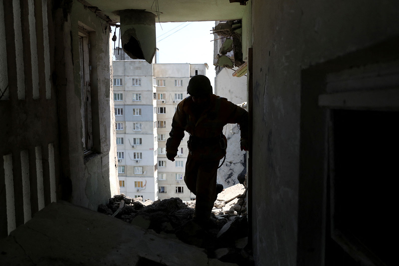 A rescuer inspects a flat where the bodies of civilians were collected from a shelled residential building in Kharkiv on May 31. 