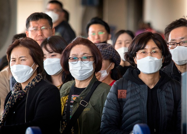 Passengers wear protective face masks as they arrive in Los Angeles on January 29, 2020.
