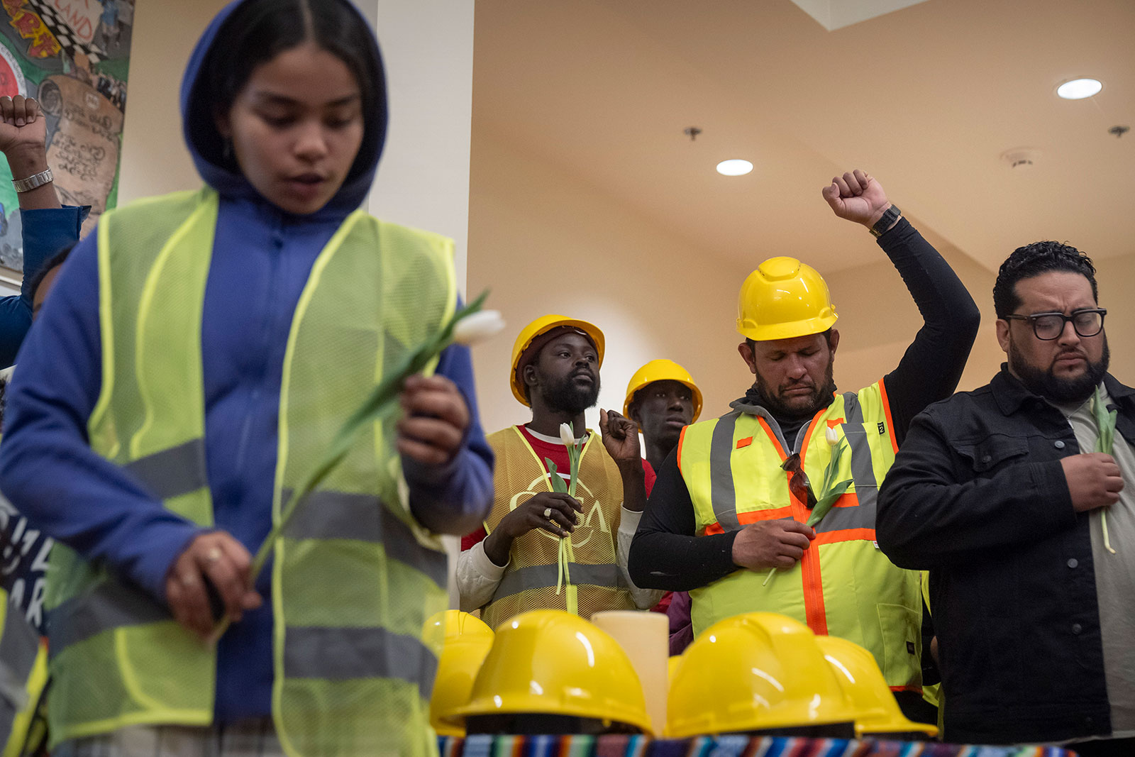 Construction workers and supporters reflect during a moment of prayer at a vigil and press conference by CASA of Maryland on Friday in Baltimore.