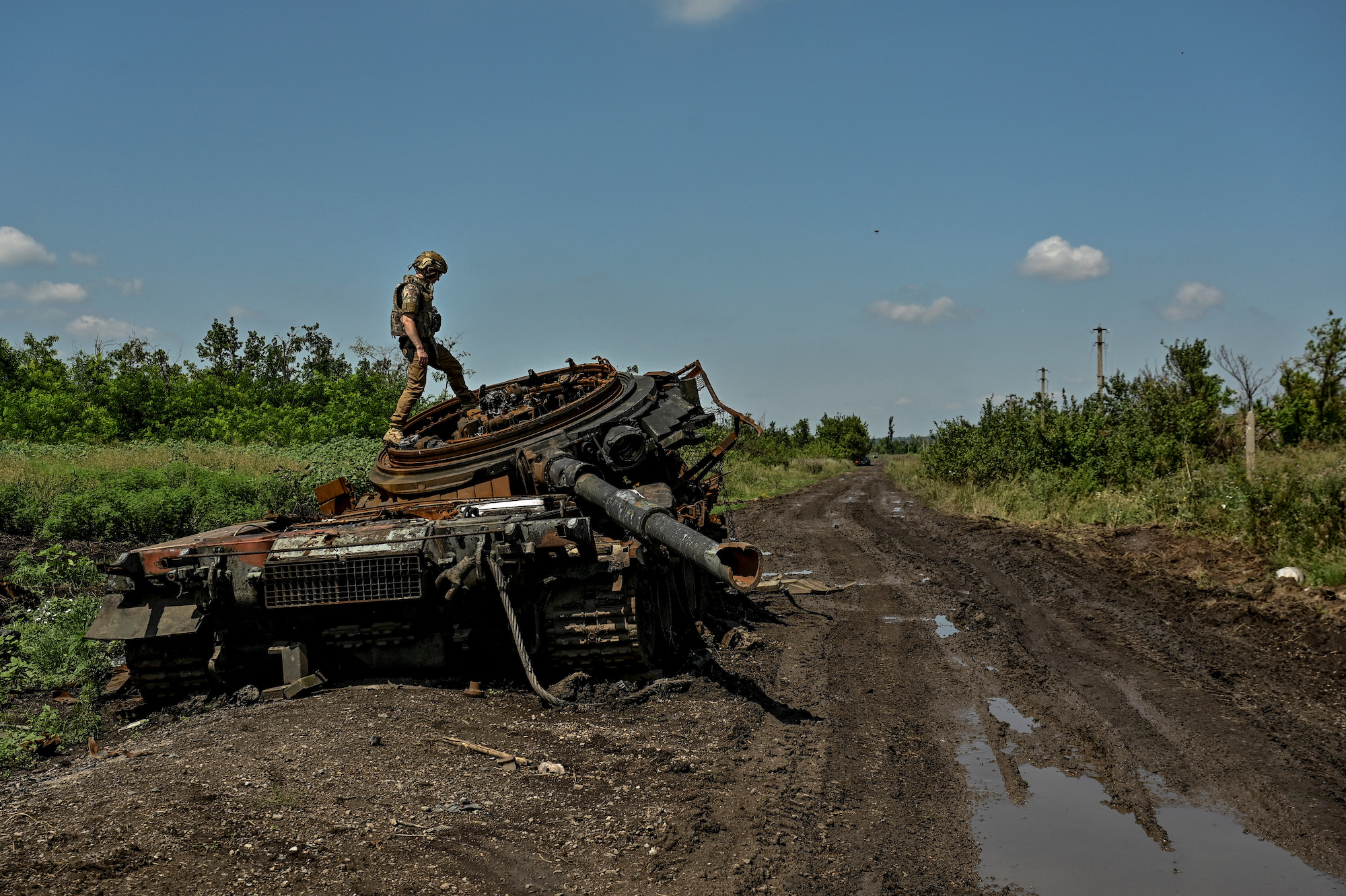 A Ukrainian serviceman inspects a destroyed Russian tank in the Zaporizhzhia region on July 21.