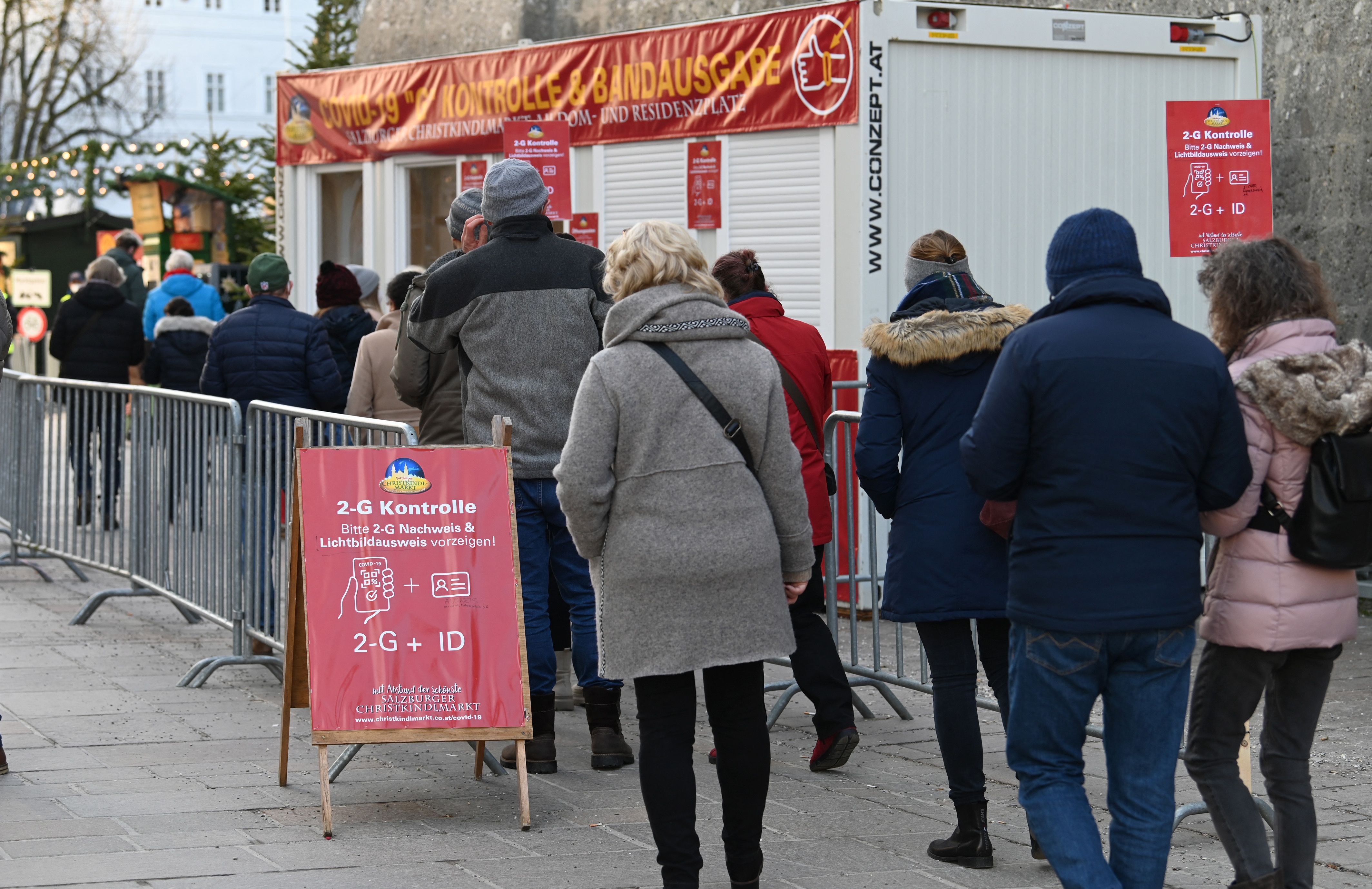 People queue at a vaccine certificate control booth at the Christmas market in Salzburg on December 17, 2021.