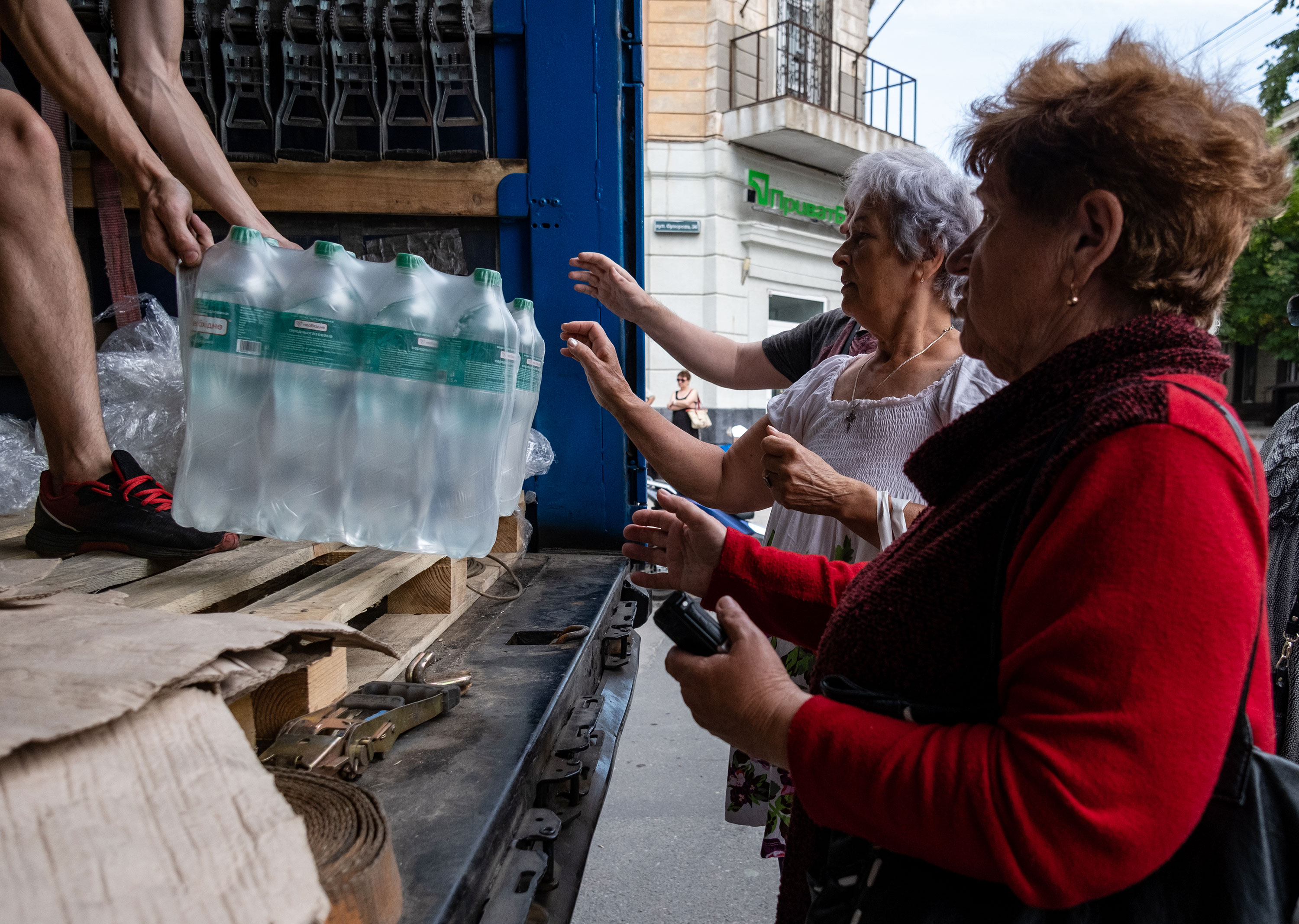 Residents of Kherson receive drinking water from volunteers on June 8. 