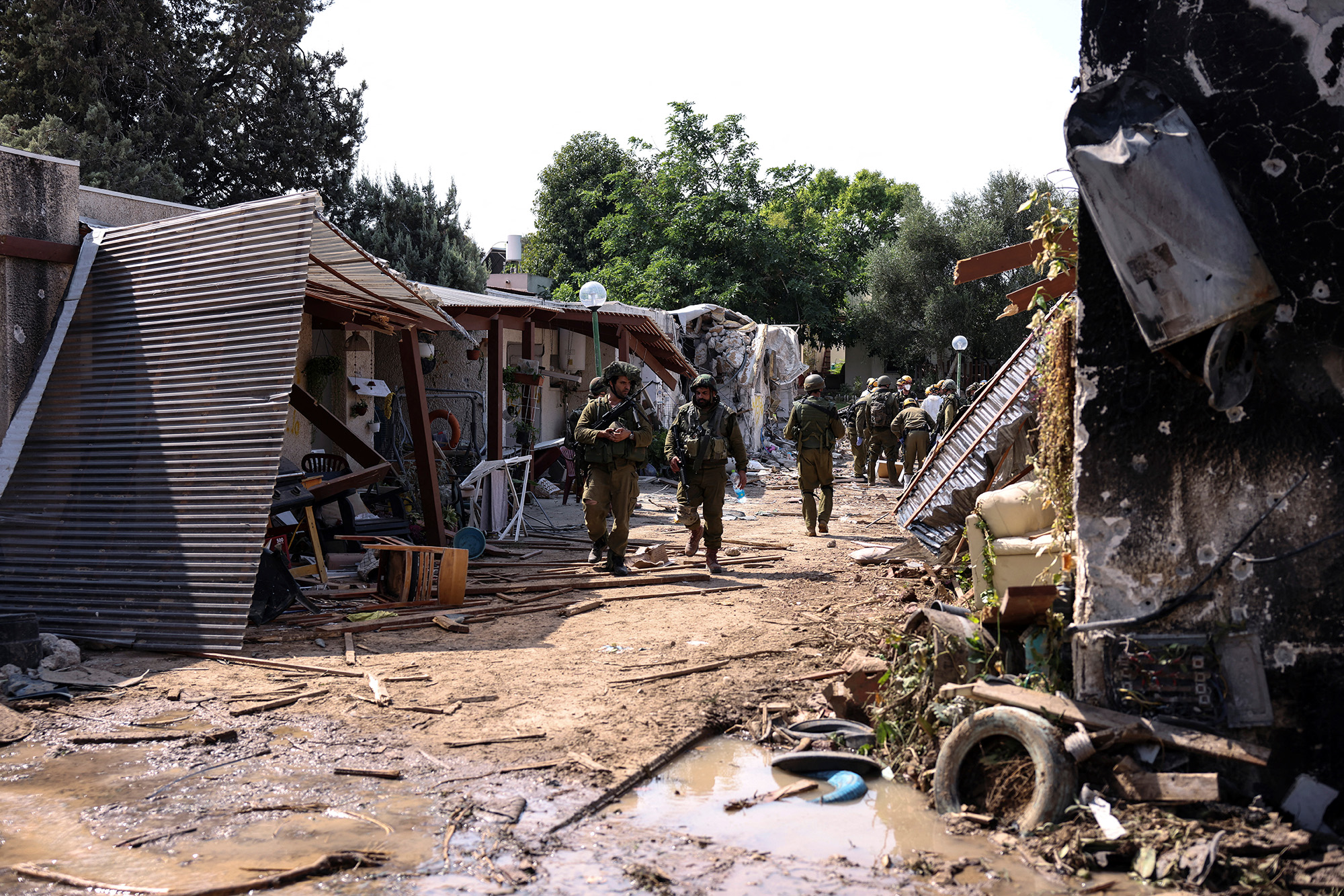 Israeli soldiers walk through the remains of a residential area of Kibbutz Kfar Aza, in southern Israel, on October 10.