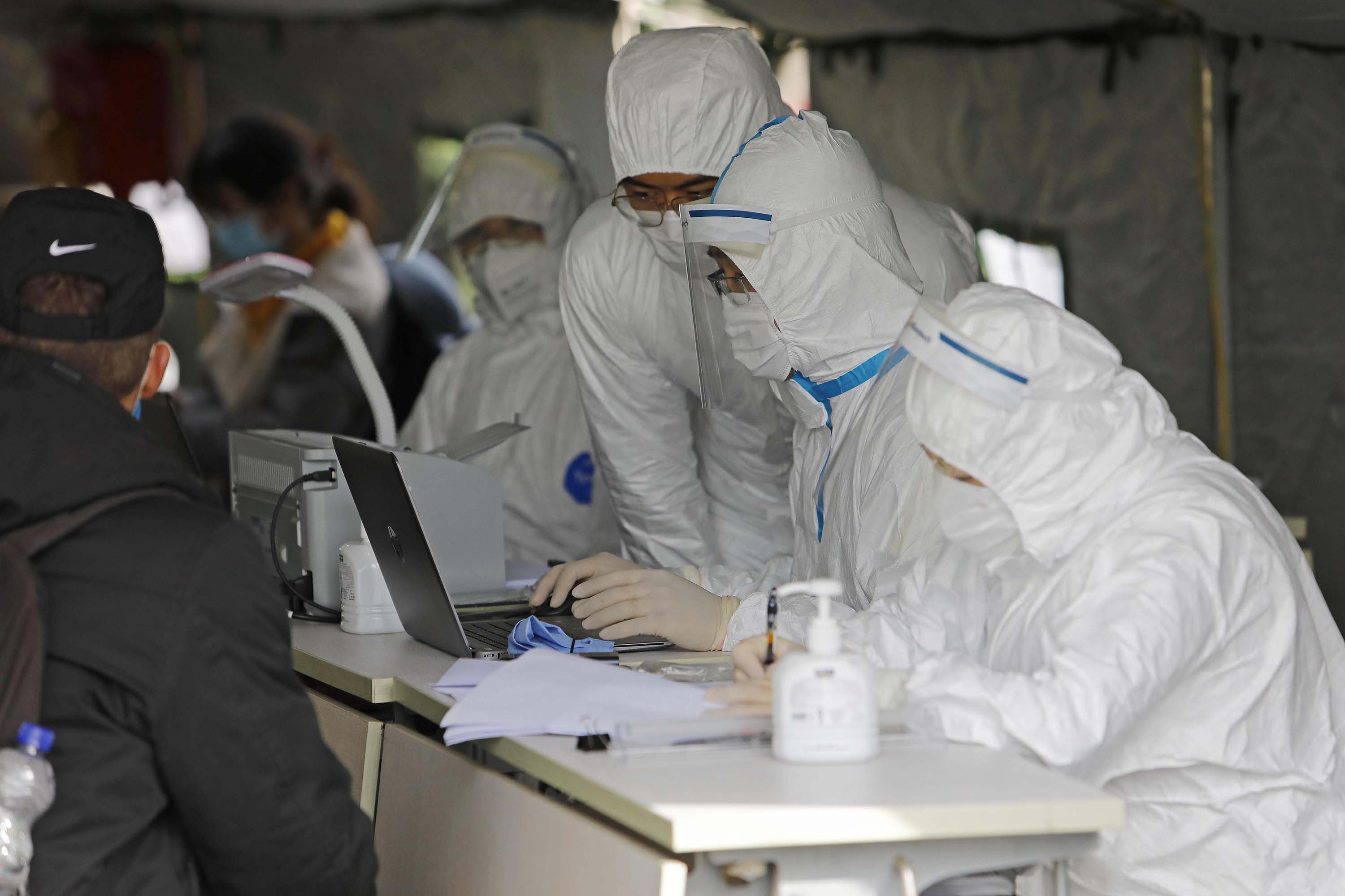 Workers record information on inbound passengers at a coronavirus screening checkpoint in Shanghai, China, on March 19.