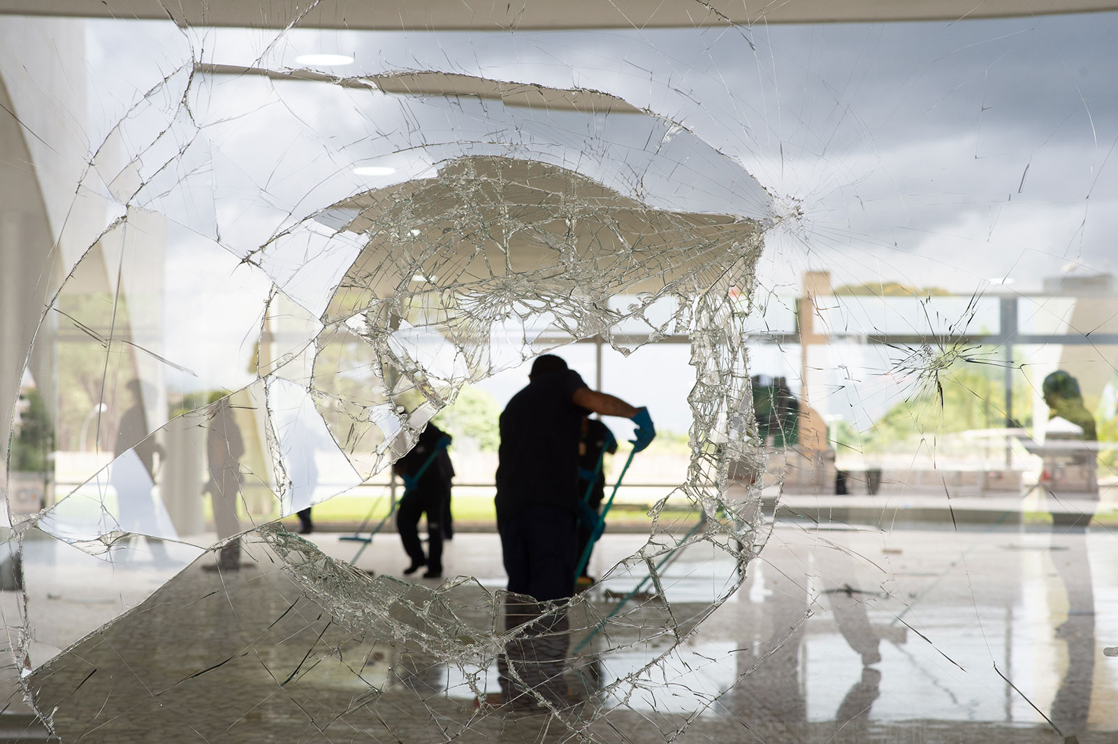 Workers clear debris caused by supporters of former President Jair Bolsonaro following a riot at Planalto Palace on January 9. 