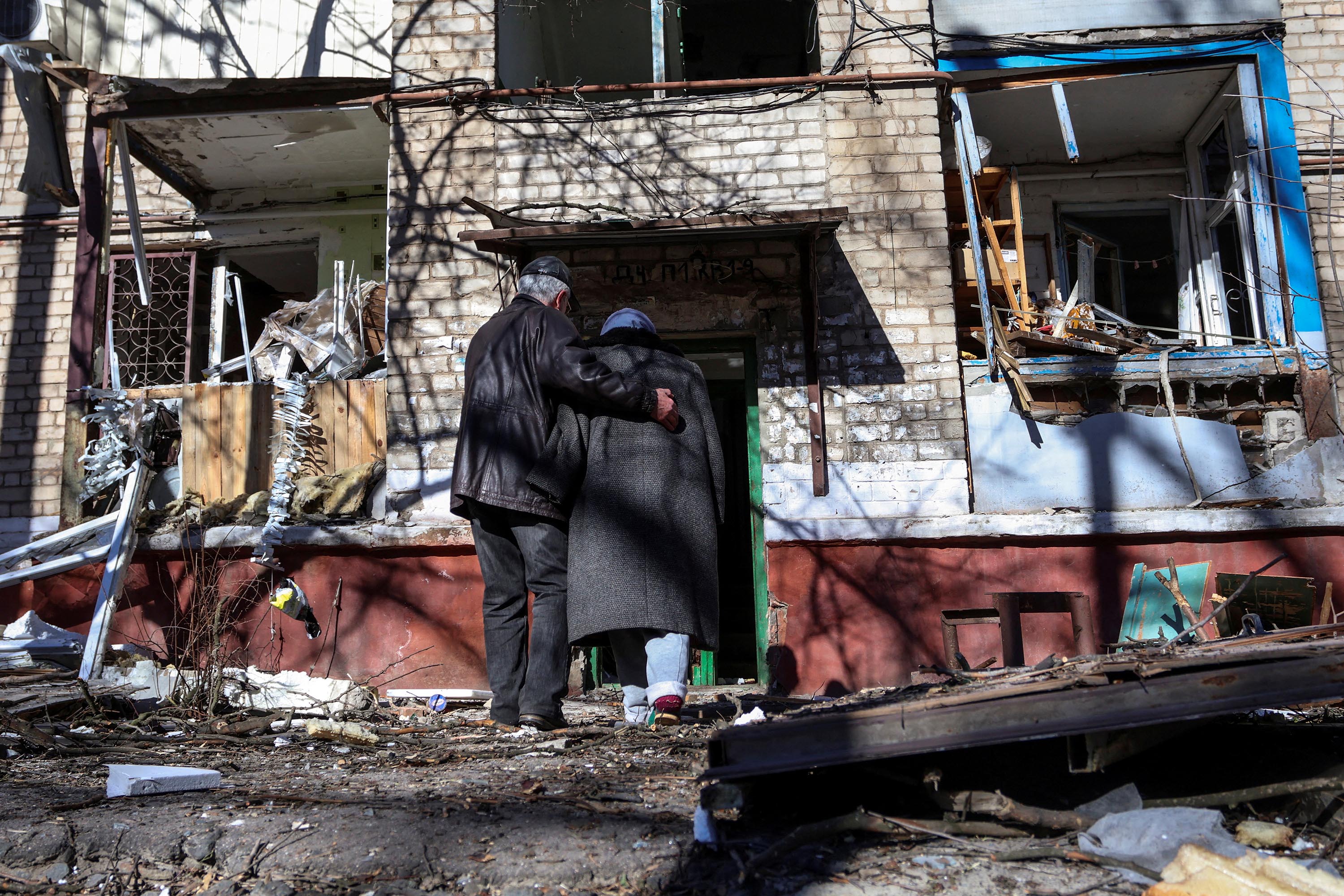 A couple enter a residential building damaged by a Russian missile strike in Kramatorsk, Ukraine, on Tuesday, March 14. 