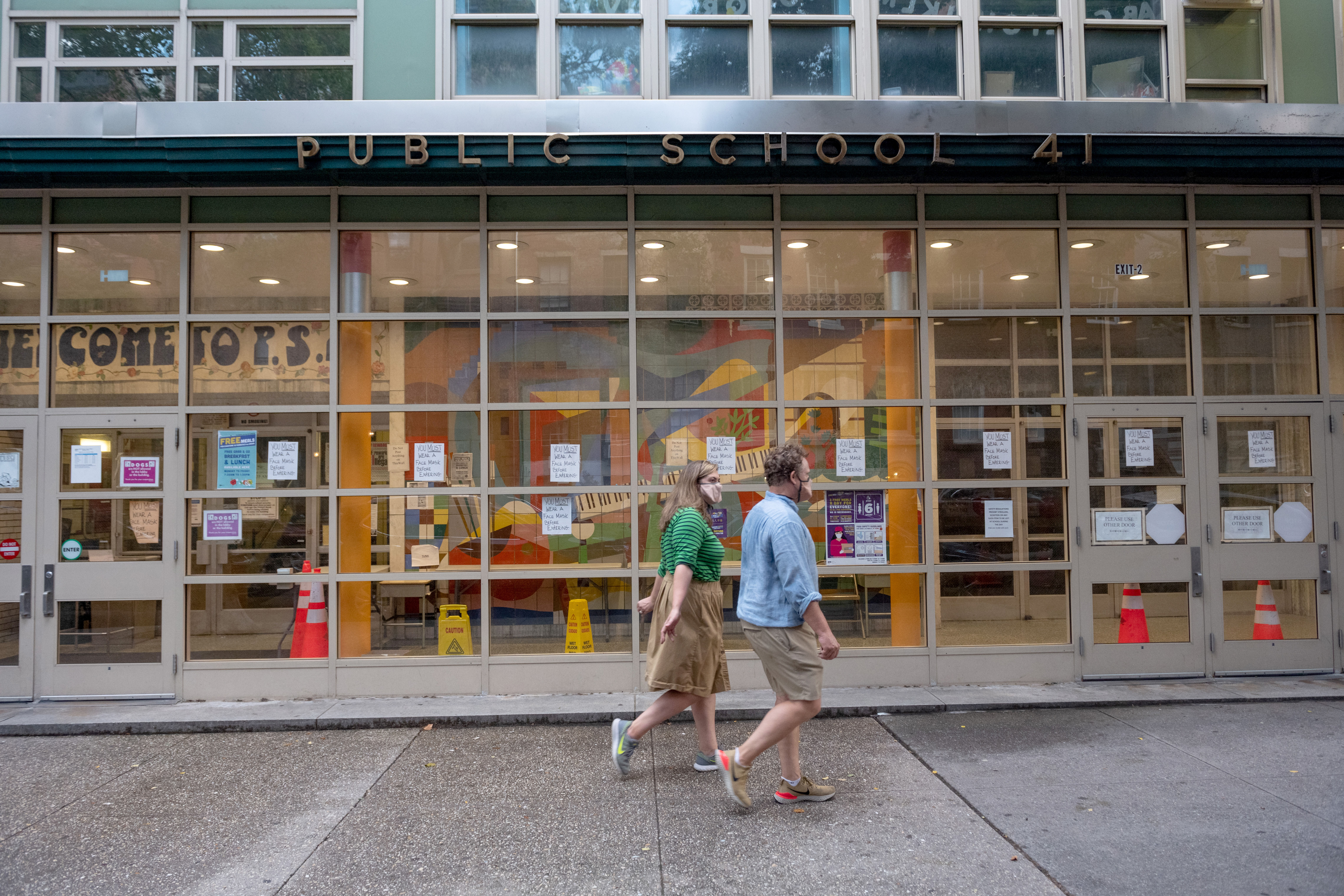 People walk past a public school in New York on July 8.