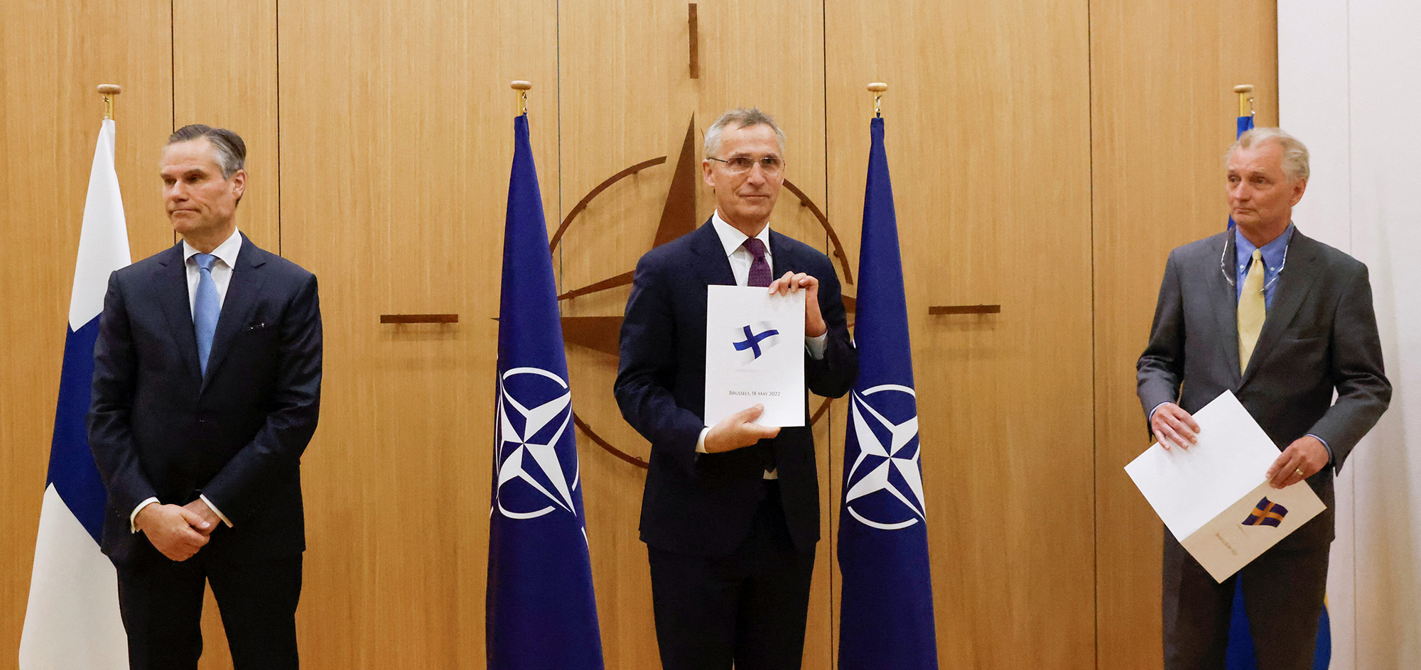 Finland's Ambassador to NATO Klaus Korhonen, left, NATO Secretary-General Jens Stoltenberg, center and Sweden's Ambassador to NATO Axel Wernhoff, right, attend a ceremony to mark Sweden's and Finland's application for NATO membership in Brussels, Belgium, on May 18.
