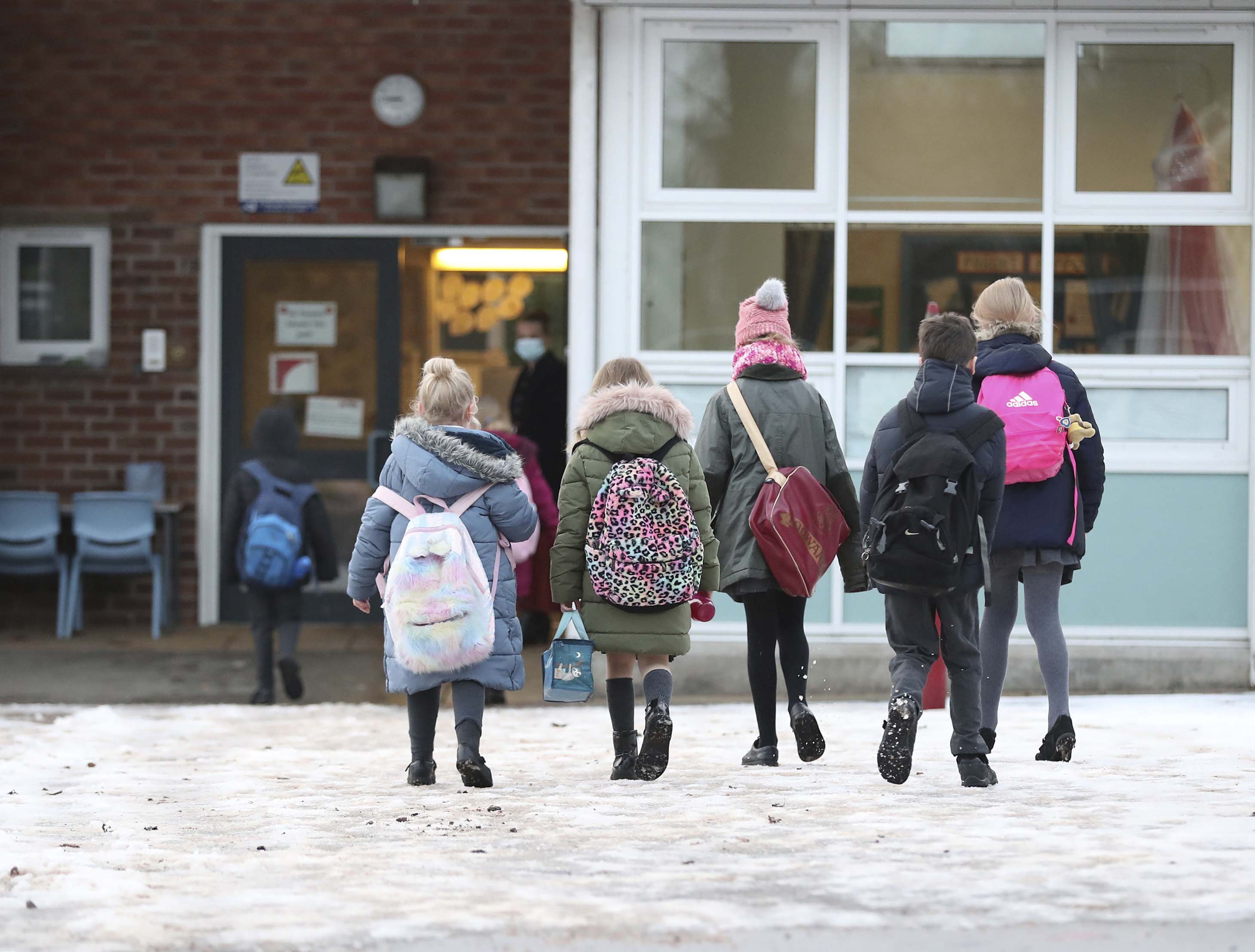 Pupils arrive at Manor Park School and Nursery in Knutsford, England, as some schools reopen on January 4 following the holiday break.