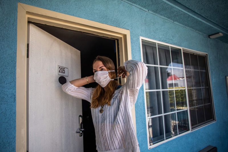 A homeless woman puts on her mask at a motel room provided to homeless people under the "Project Roomkey" program on April 26 in Venice Beach, California.