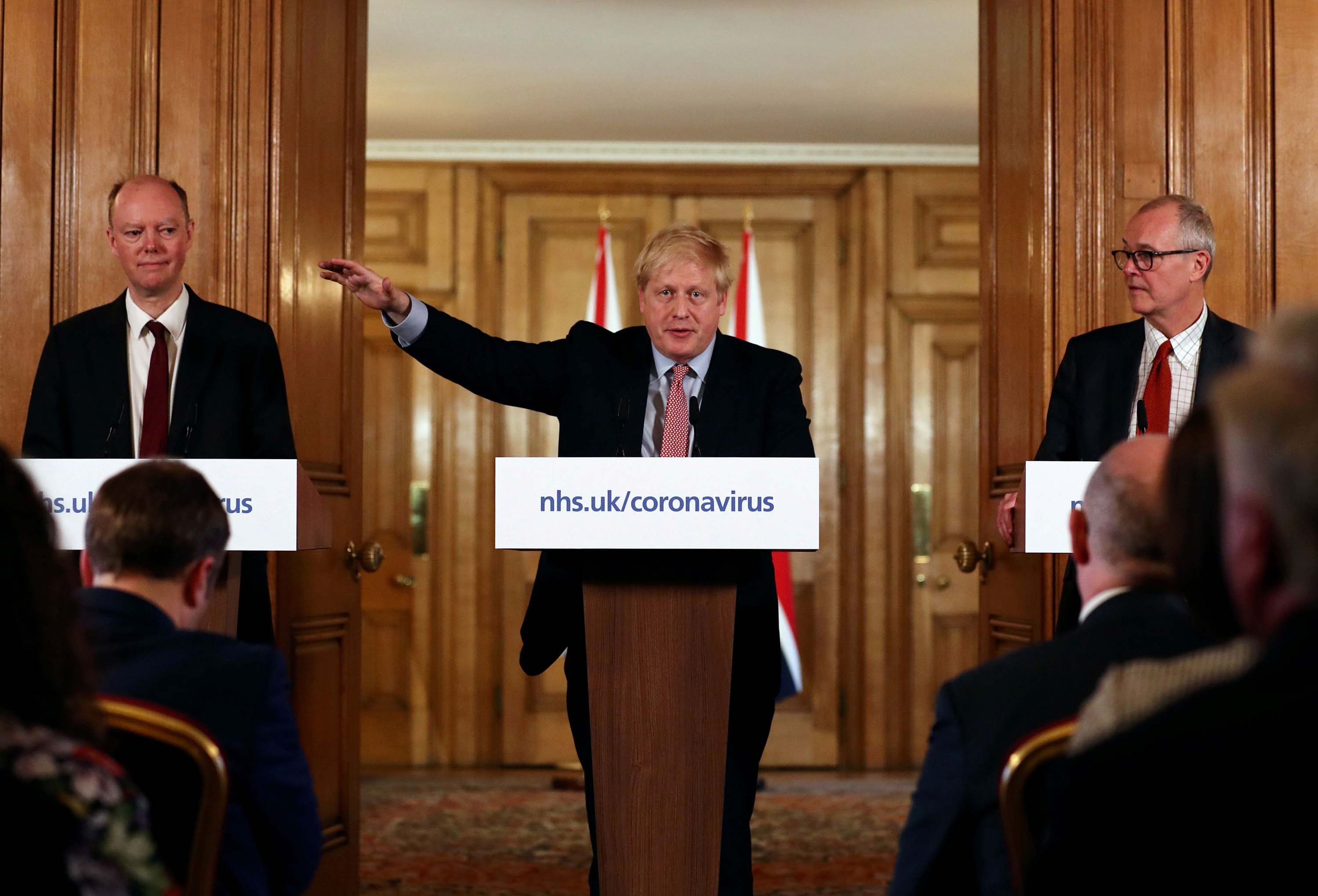 British Prime Minister Boris Johnson, center, speaks alongside Chief Medical Officer for England, Chris Whitty, left, and Government Chief Scientific Adviser, Sir Patrick Vallance during a news conference addressing the government's response to the novel coronavirus outbreak in London on March 12.