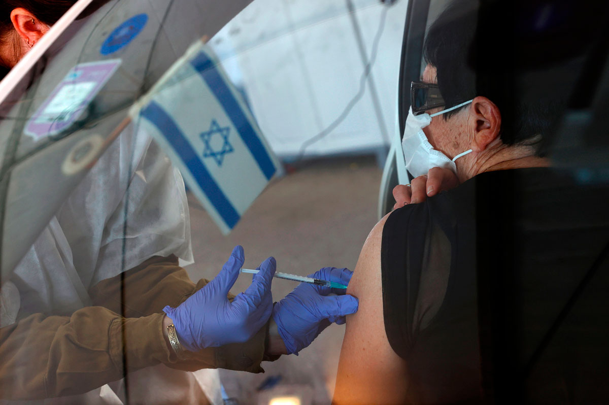 An Israeli senior citizen receives her second Pfizer Covid-19 vaccine at the Maccabi Health Services drive-in vaccination center, in the northern coastal city of Haifa on January 11.