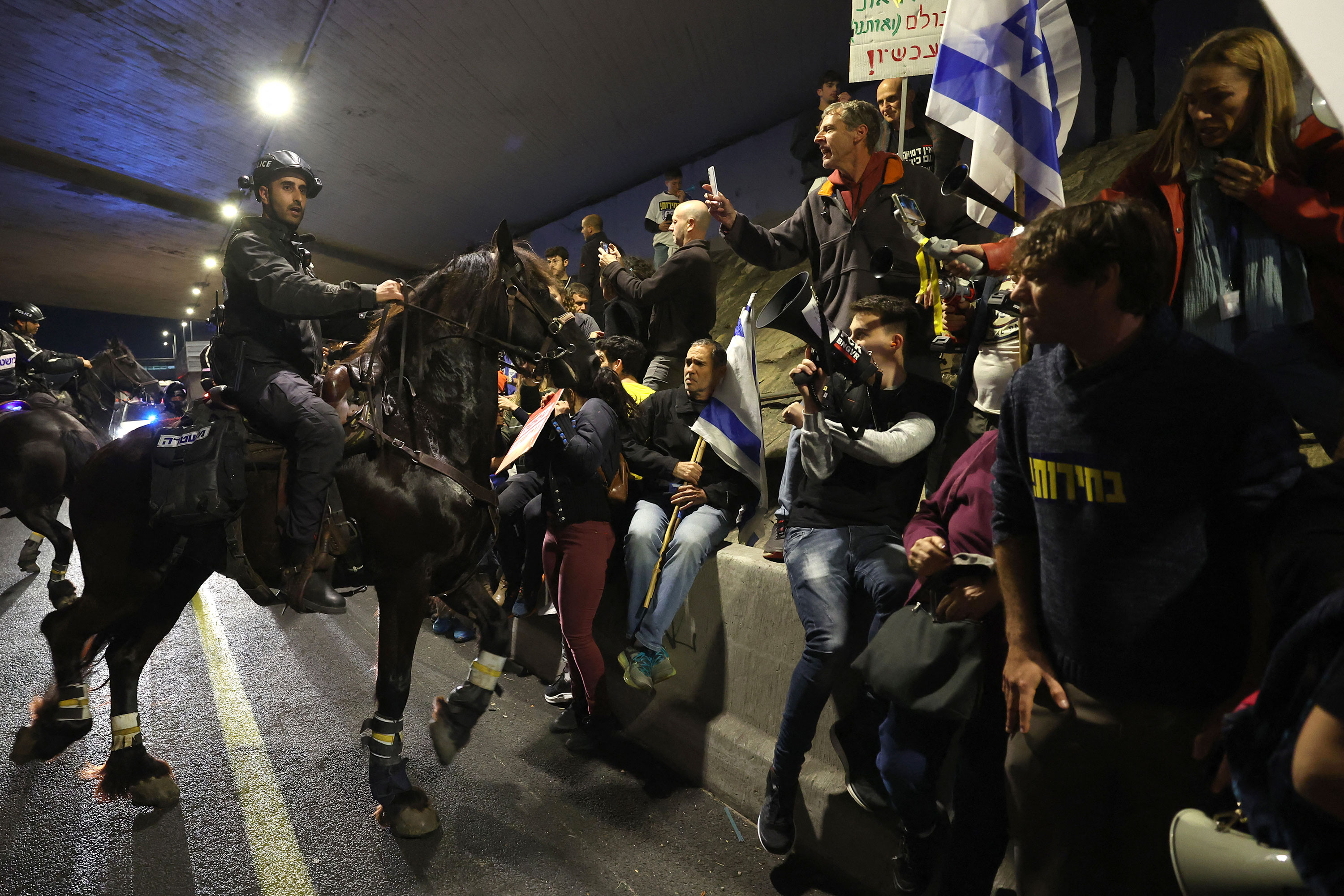 Mounted Israeli security forces push protesters away from a road during a demonstration in Tel Aviv on March 9. 