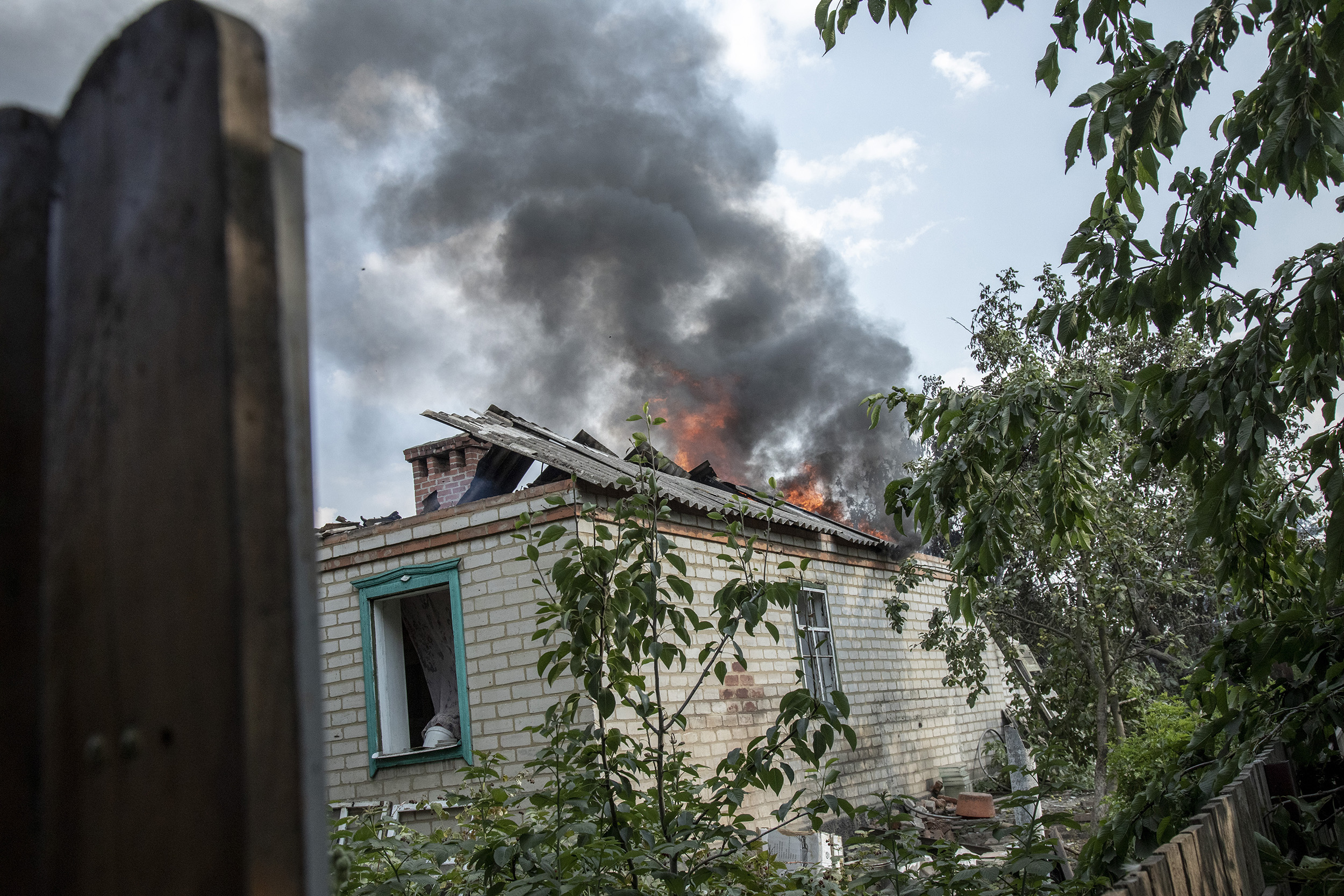 Під час бомбардування у Верхньокам'янську, Україна, 4 липня горить будинок.