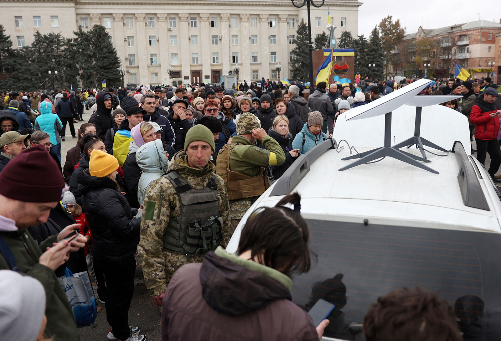 Residents use their mobile phones near a Starlink satellite broadband station in Kherson, Ukraine November 13. 