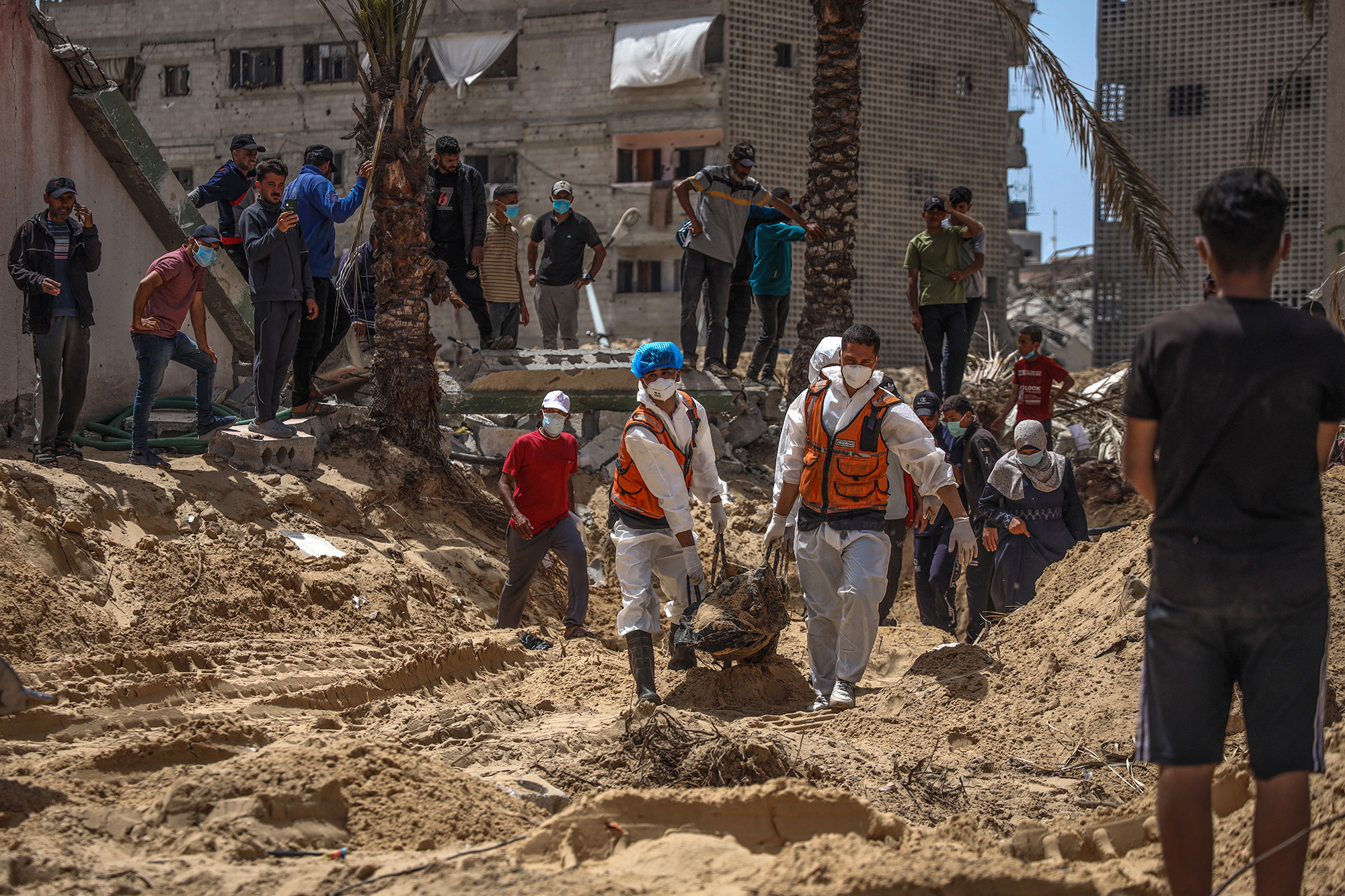 People and health workers unearth bodies found at Nasser Hospital in Khan Younis, Gaza, on April 23.